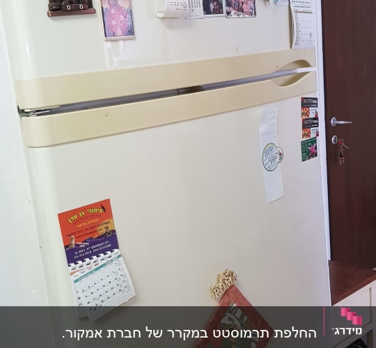 מקרר עם מגנטים, תמונות ומסמכים על הדלת